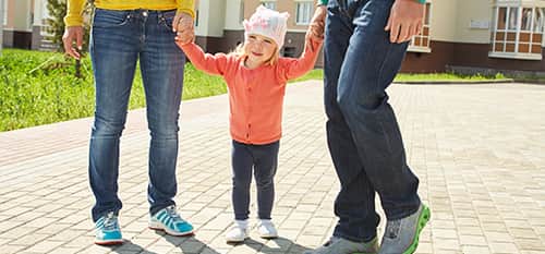 toddler holding hands with two adults