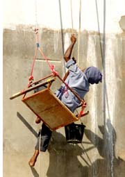 painter hanging precariously